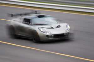 A fast silver sports car speeding down the road getting a speeding ticket